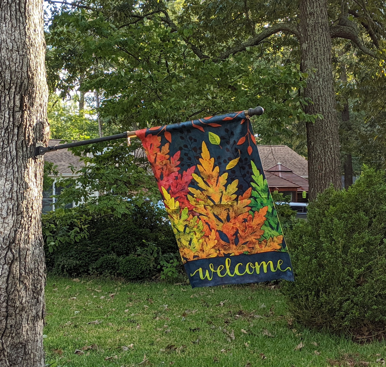 Welcome garden flag with autumn leaves hanging in yard