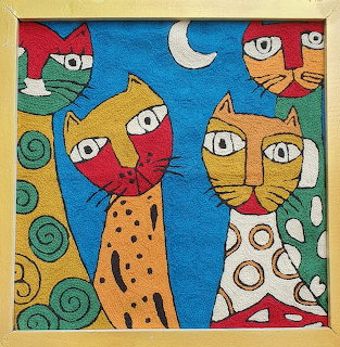 Five colorful folk art cats with large eyes and decorative patterns arranged together under a crescent moon