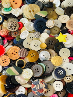 Assorted vintage sewing buttons in multiple colors and styles arranged closely together