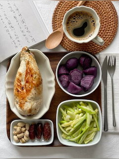 Wooden tray with baked bread, purple sweet potato chunks, celery, nuts, dates, and a cup of coffee