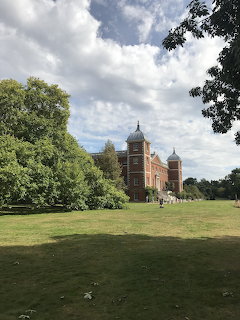 Osterley House historic red-brick mansion with towers surrounded by green lawn and trees, UK