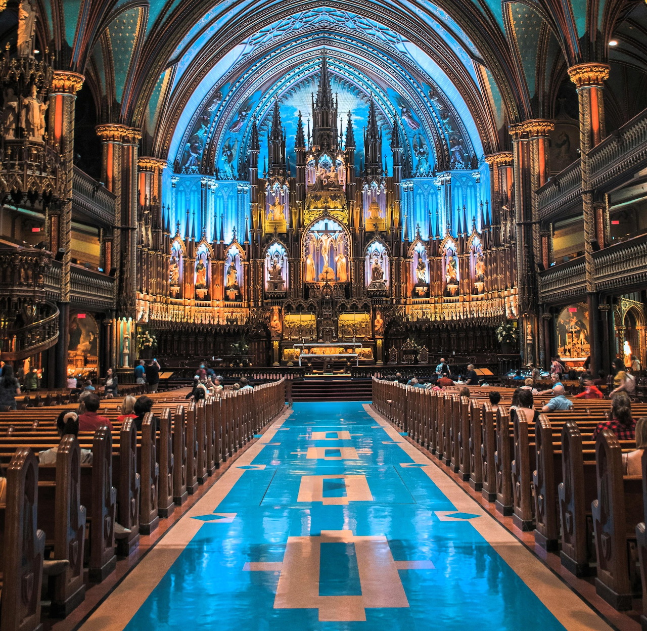 Ornate blue and gold church interior with vaulted ceiling, altar, and central aisle