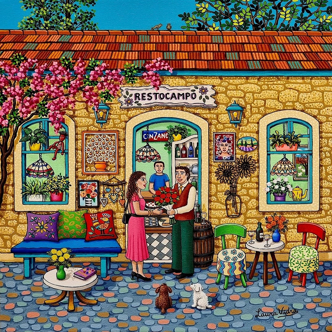 Folk art painting showing couple at outdoor cafe in colorful village scene with flowering trees and stone architecture