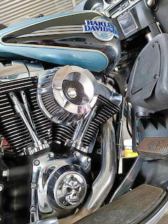 Close-up of a Harley-Davidson motorcycle engine with chrome details and blue tank trim