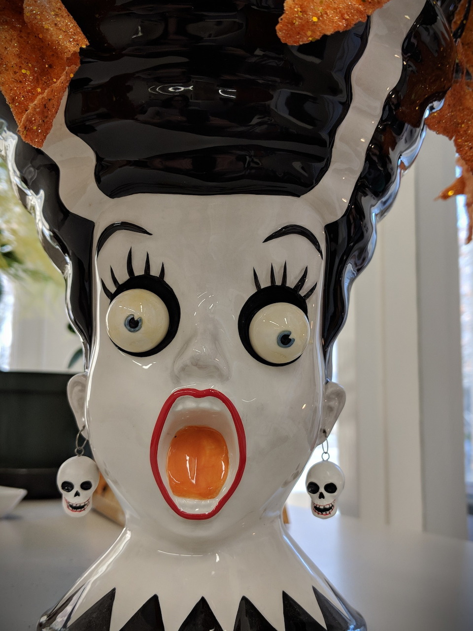 White ghostface scream mask with elongated open mouth on dark background