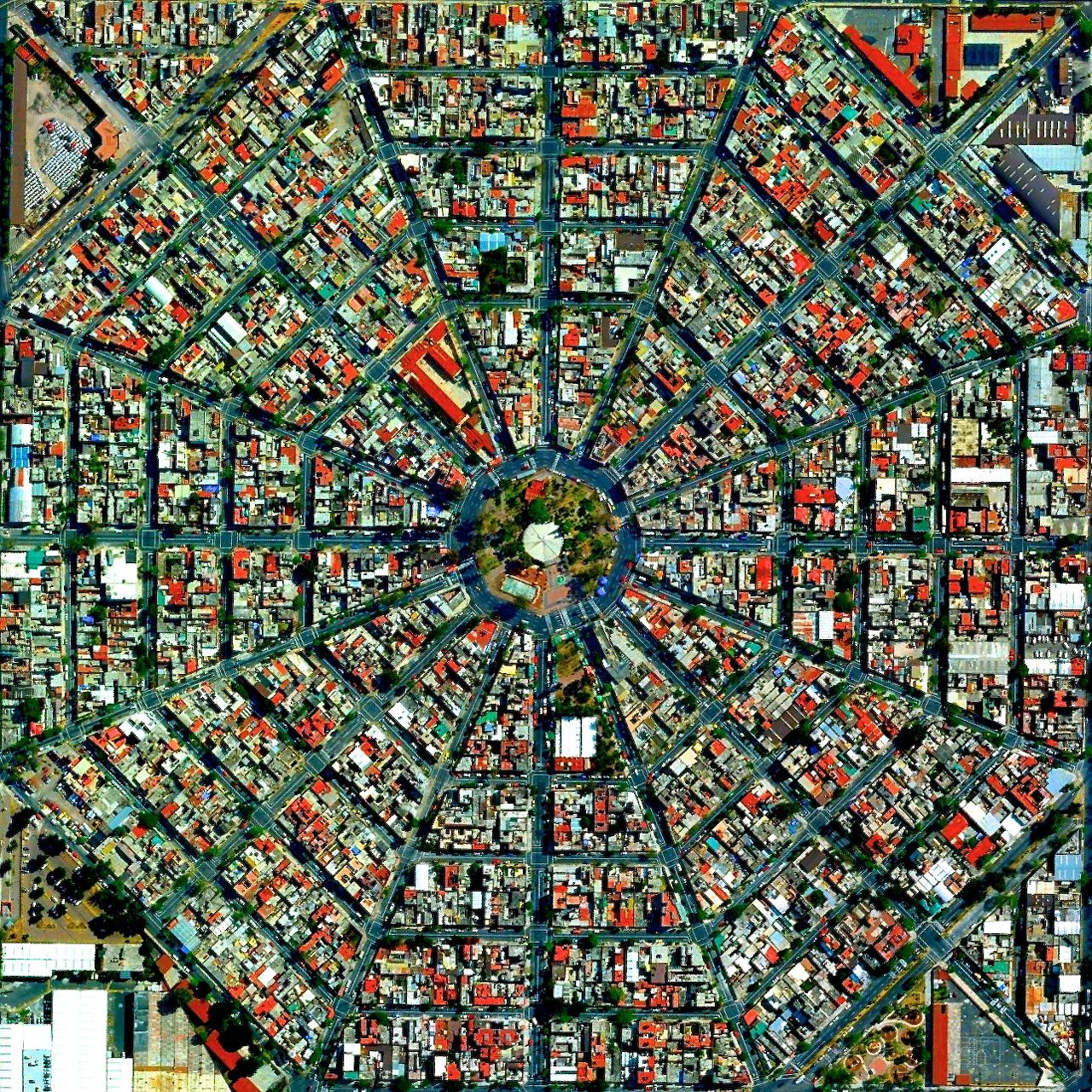 Overhead satellite view of circular plaza with radiating streets and surrounding city blocks in Mexico