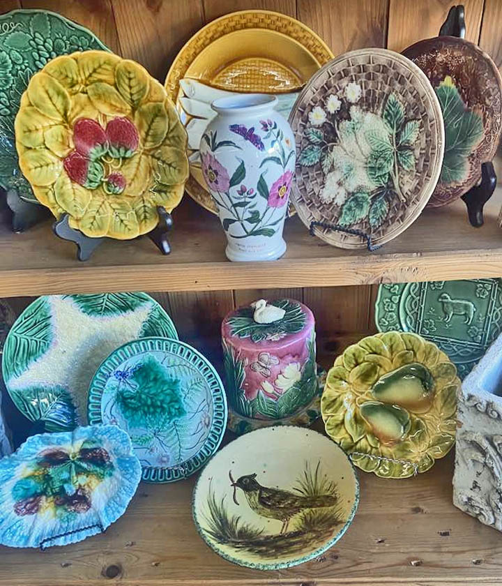 Decorative ceramic plates and cups arranged on wooden shelves