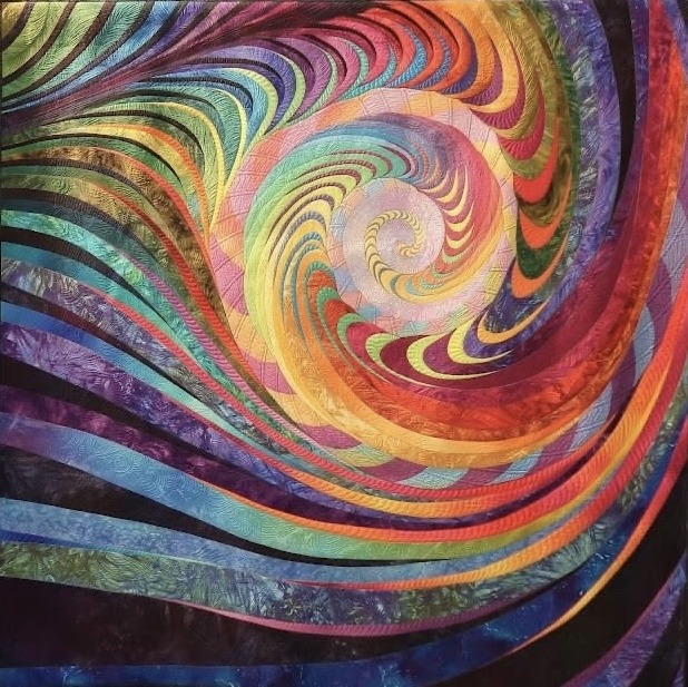 Colorful abstract quilt with swirling rainbow spiral pattern radiating from center in rich jewel tones