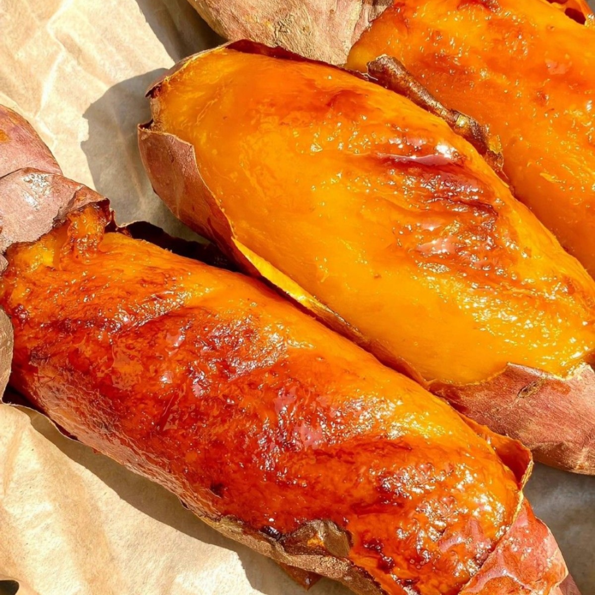 Close-up of roasted sweet potatoes with glossy orange flesh and browned skins