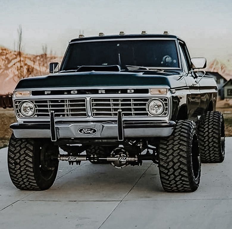Black lifted Ford pickup truck with large off-road tires seen from the front