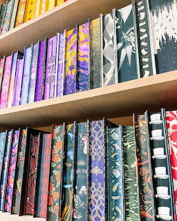Wooden bookshelf with colorful books and decorative objects on multiple shelves