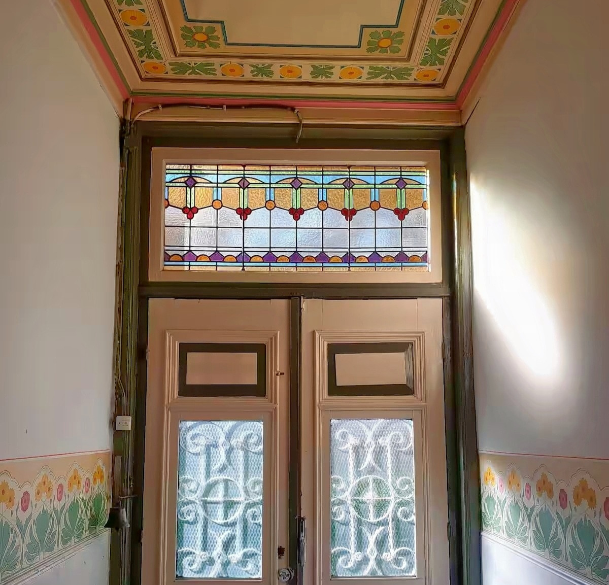 Art Nouveau double doors with stained glass transom and painted ceiling details