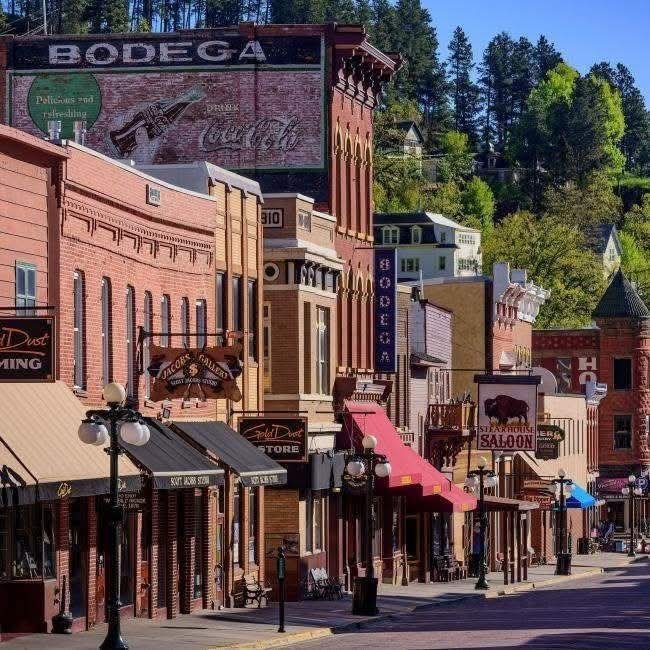 Historic Main Street of Deadwood with brick buildings and mountain backdrop