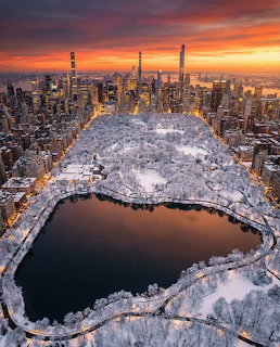 Aerial view of snow-covered Central Park in New York City at sunset with Manhattan skyline