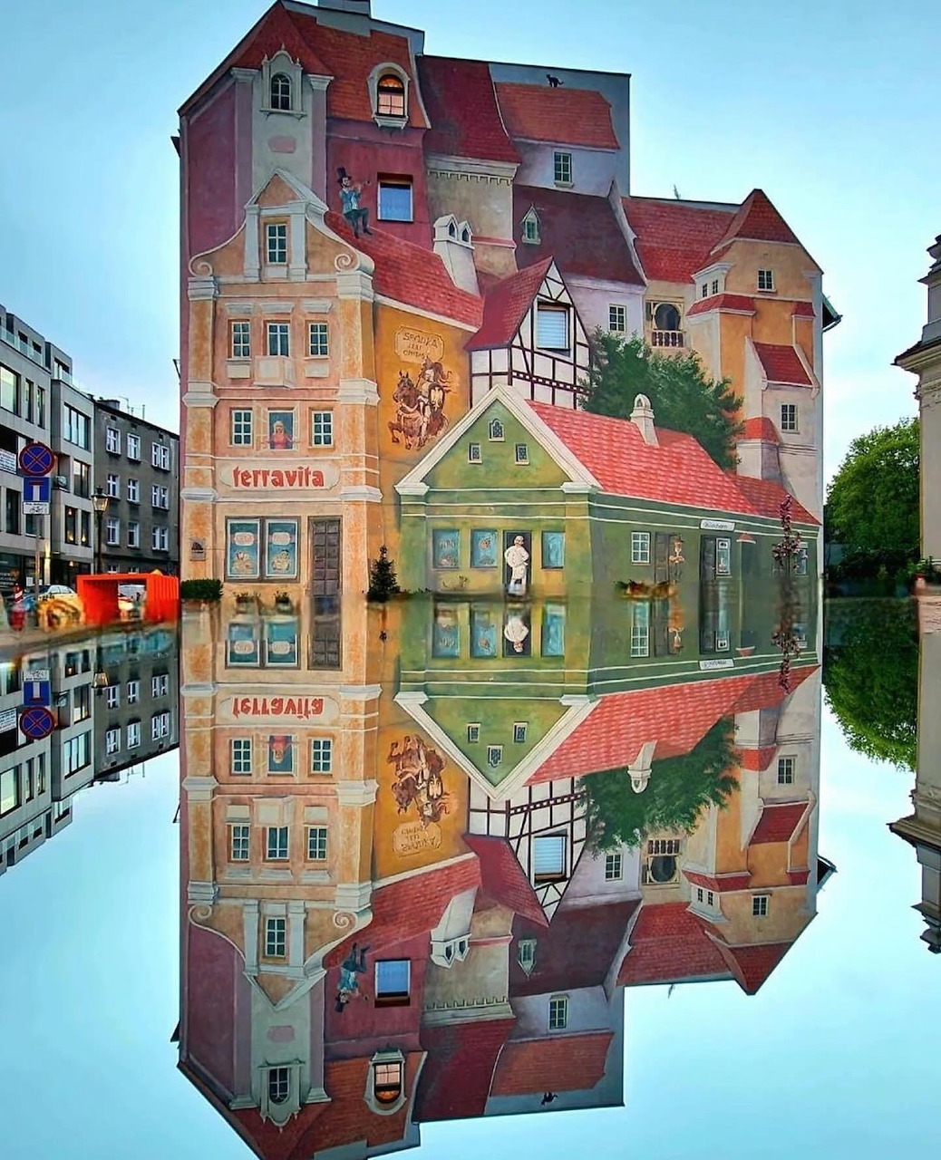 Colorful European building mirrored in calm water with perfect symmetry
