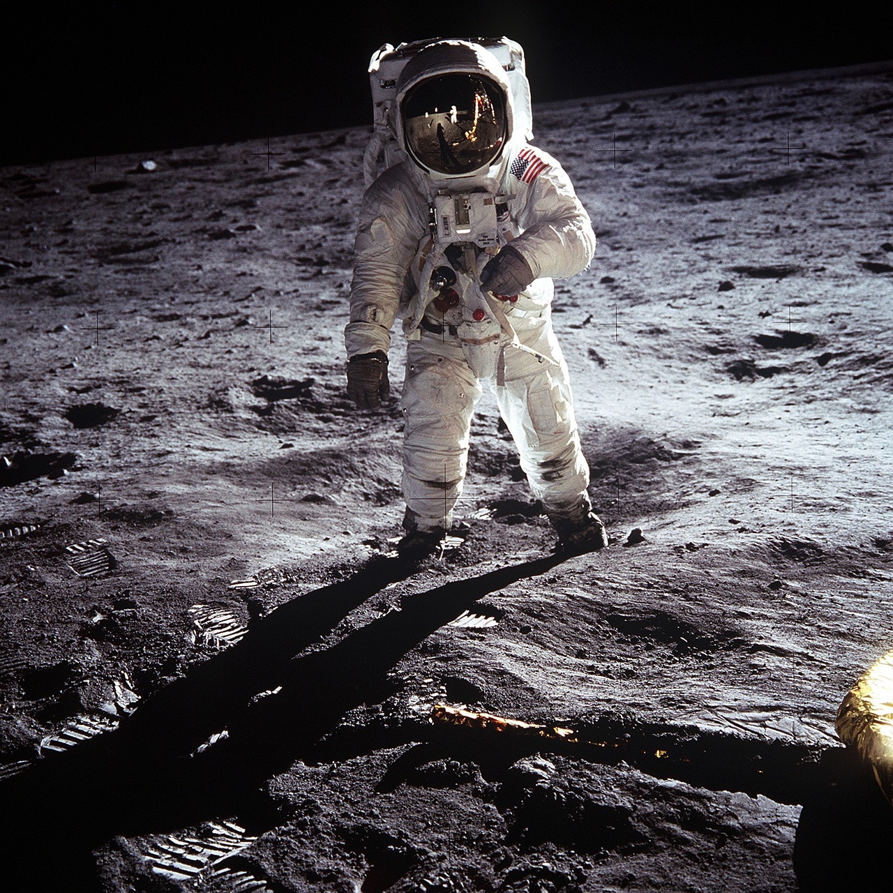 Astronaut standing on the moon on a dusty rocky surface beneath a black sky