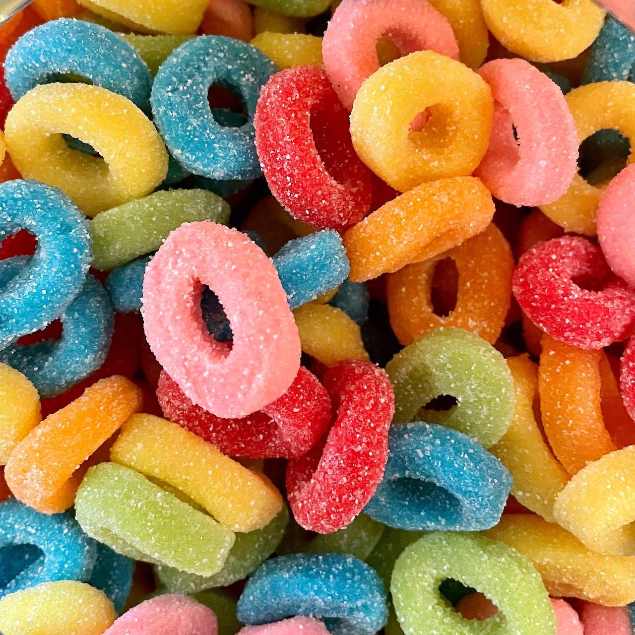 Pile of colorful sugar-coated ring-shaped gummy candies in various bright colors