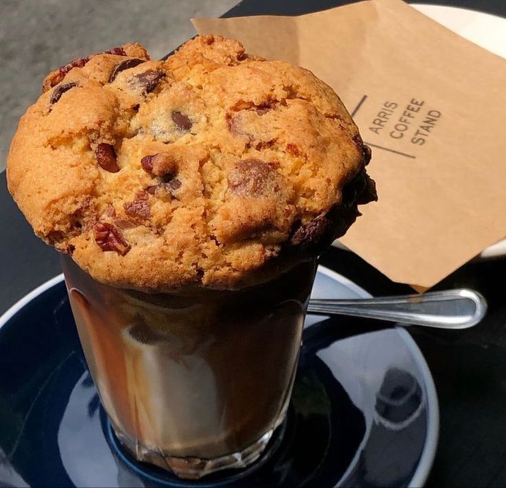 Iced coffee in glass topped with chocolate chip cookie on blue saucer