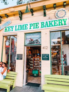 Key Lime Pie Bakery storefront with green benches and open door showing interior shelves