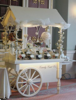 White decorative candy cart with cupcakes and sweets indoors