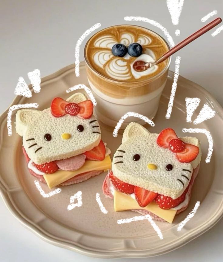 Two Hello Kitty-shaped bread sandwiches with strawberries and cheese beside a latte on a plate
