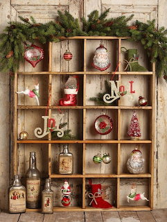Rustic wooden shelf with Christmas ornaments, greenery, bottles, and festive decor