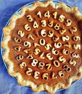 Pie decorated with pastry numbers showing digits of pi in spiral pattern