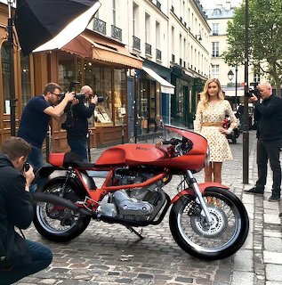 Red Laverda 750SF motorcycle on cobblestone street with photographers and pedestrians in Paris