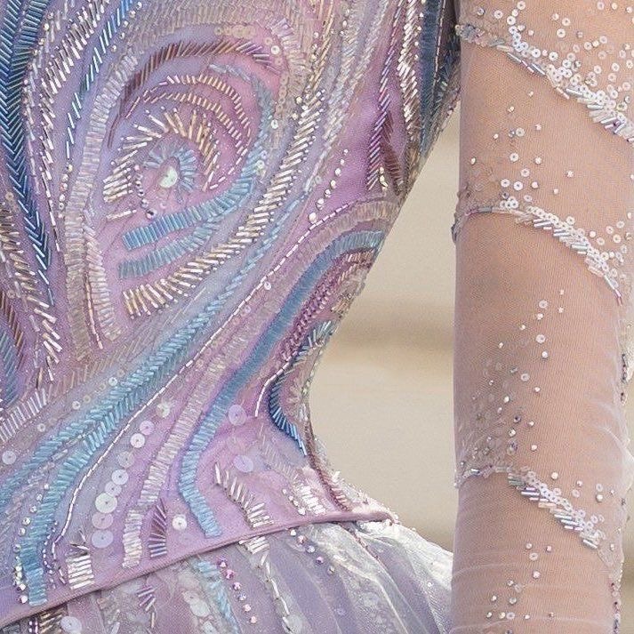 Close-up of a pastel beaded dress with sequins, embroidery, and a sheer embellished sleeve