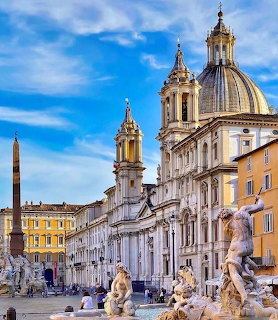Baroque church, fountain statues, and obelisk in Rome's Piazza Navona under a blue sky