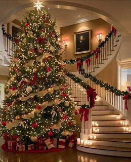 Decorated Christmas tree beside a curved staircase with garlands and bows indoors