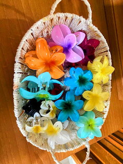 Colorful flower-shaped claw clips on a woven basket over a wooden surface