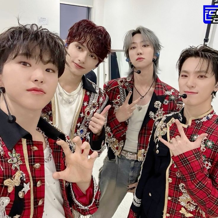 Four young men in red plaid outfits posing together indoors
