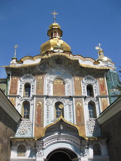 Golden-domed Orthodox cathedral with ornate baroque facade and religious frescoes at Kyiv Caves Lavra monastery