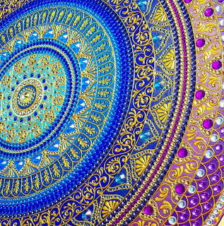 Colorful spiral mandala with blue, gold and purple rhinestone embellishments in concentric circular patterns
