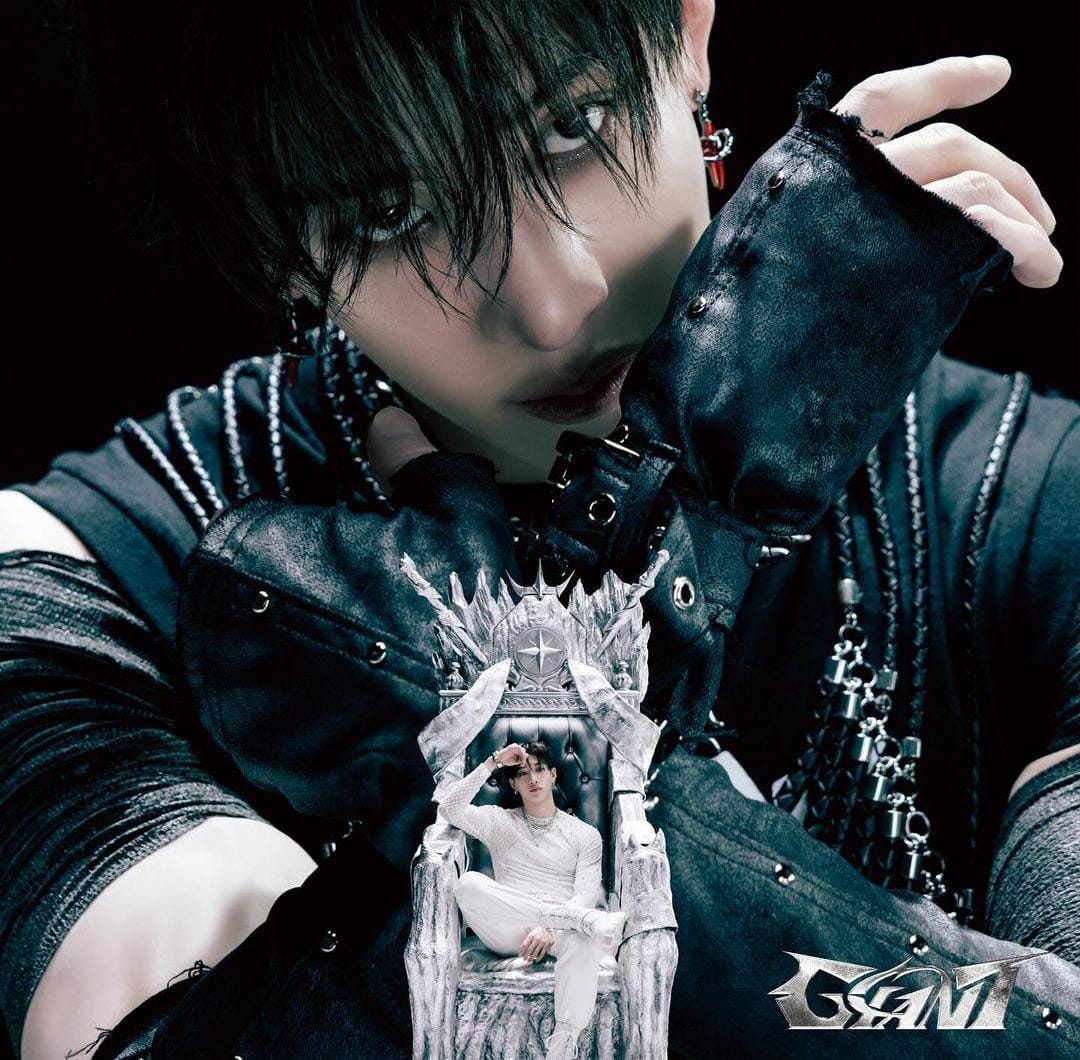 Visual kei performer with black hair and studded leather jacket holding ornate white decoration
