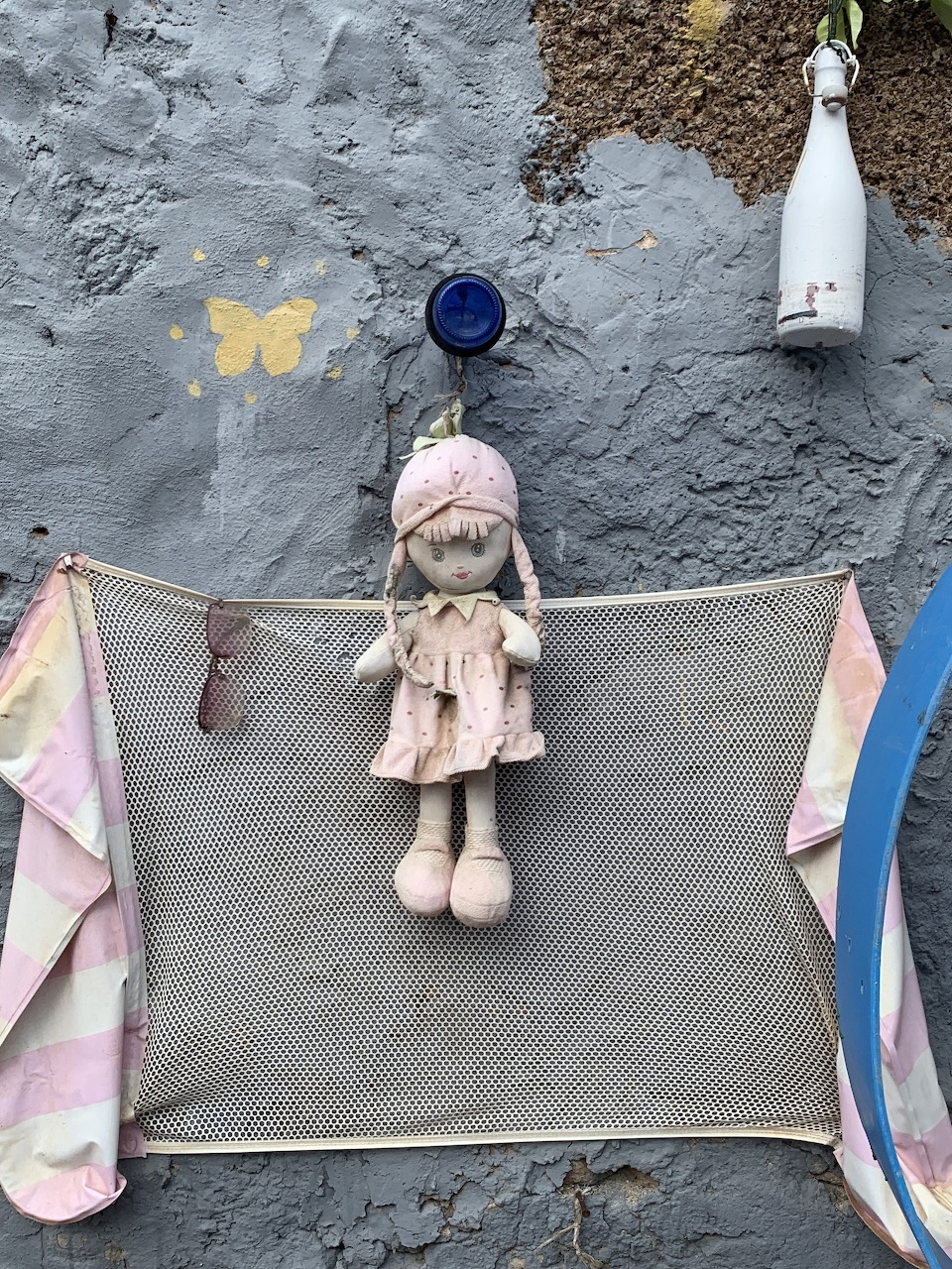 Collection of vintage dolls arranged in an outdoor garden on Lanzarote