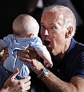 Older man with white hair holding a baby and making a surprised face