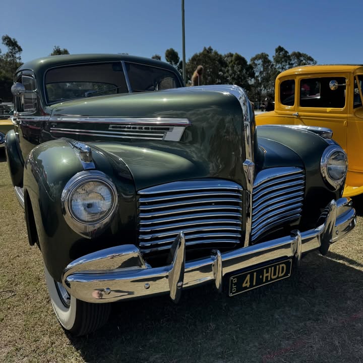 Dark green 1941 Hudson classic car with chrome grille at an outdoor car show