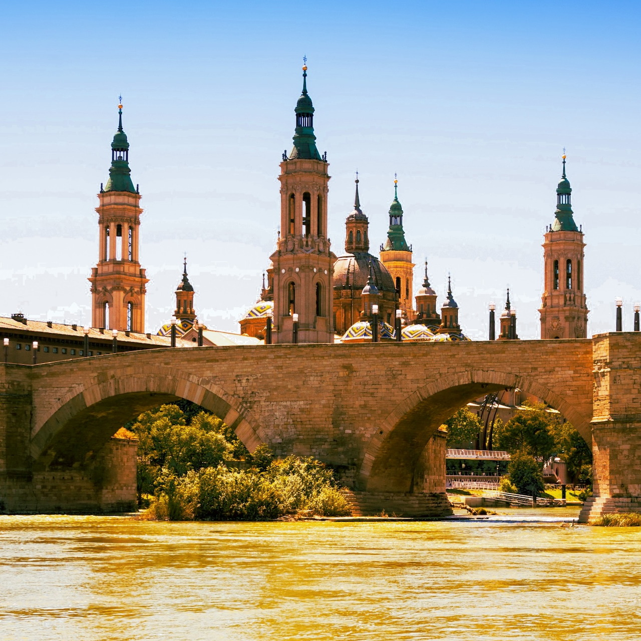 Basilica del Pilar cathedral with towers and stone bridge over river in Zaragoza Spain