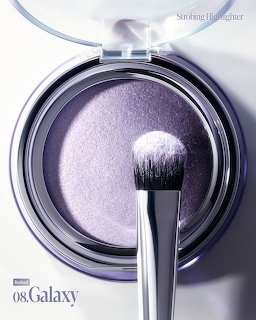 Purple shimmery highlighter compact with makeup brush on light background