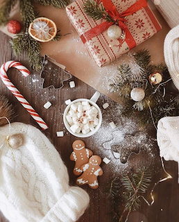 Overhead view of Christmas hot chocolate with marshmallows, gingerbread cookies, candy canes, and holiday decorations