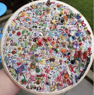 Round embroidery hoop packed with colorful stitched mini designs on white fabric