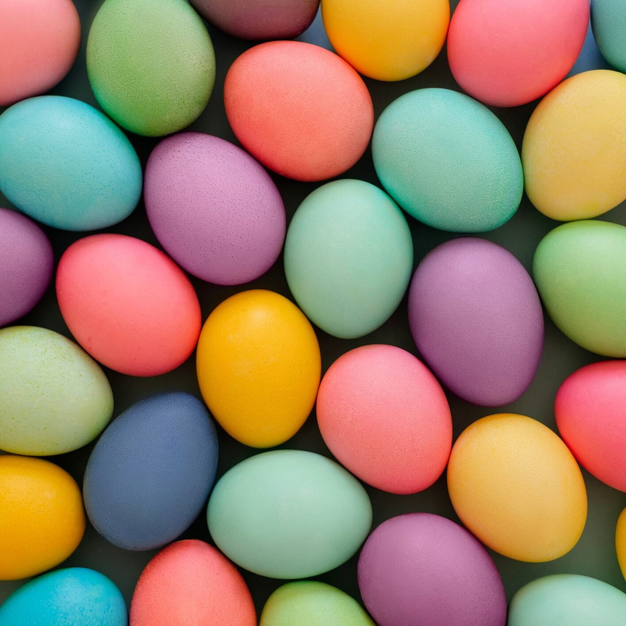 Colorful pastel Easter eggs in pink, blue, yellow, green, and purple arranged in a group