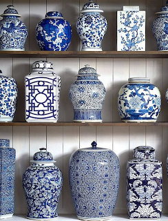 Shelves displaying ornate blue and white porcelain jars with decorative lids and traditional Chinese patterns