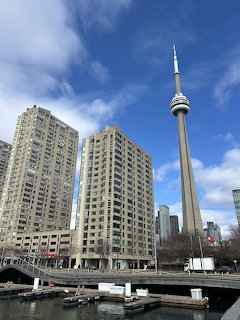 CN Tower next to high-rise apartment buildings under a blue sky