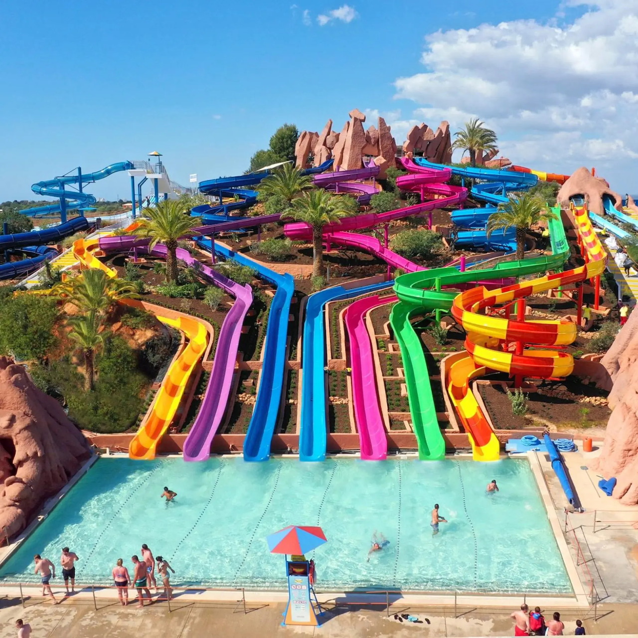 Multicolored water slides leading into a pool at an outdoor waterpark