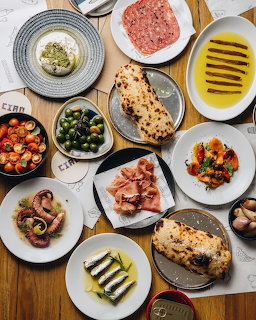 Overhead view of Mediterranean dishes with flatbread, vegetables, and olives on colorful plates