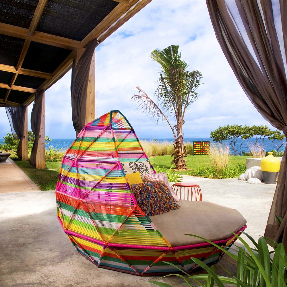 Colorful striped hanging egg chair on beachfront patio with ocean view