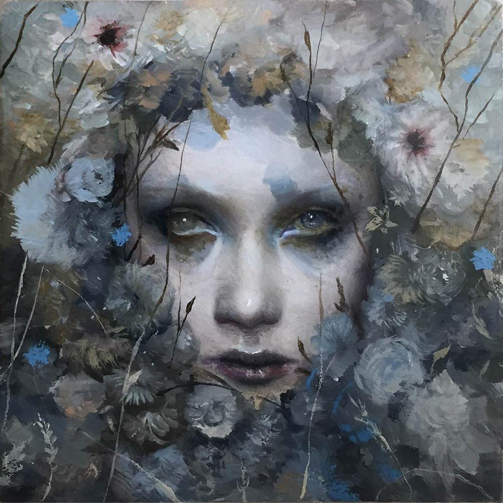 Surreal portrait of woman with flowers and foliage integrated into her hair and surrounding her face